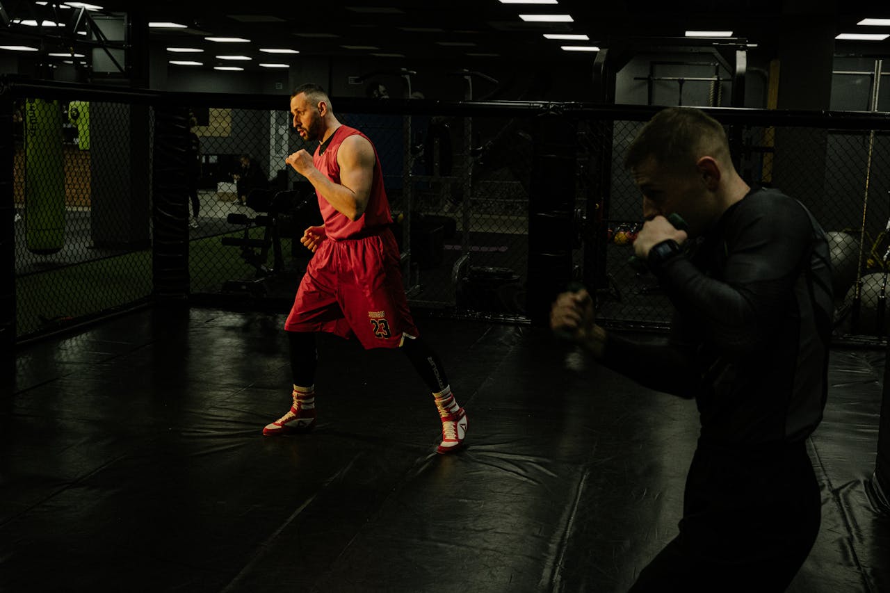Crafting Captivating Headlines: Your awesome post title goes here Two men practice boxing techniques in a dimly-lit gym, focusing on form and agility.